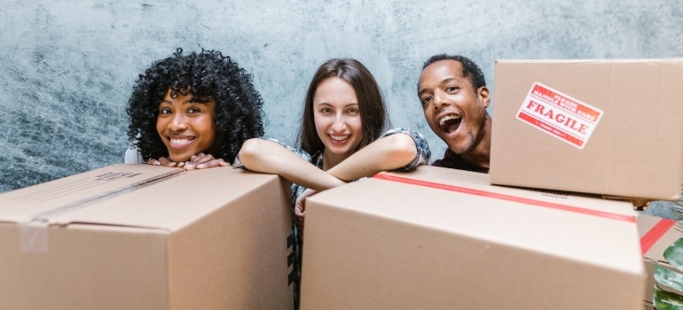 three people behind boxes smiling