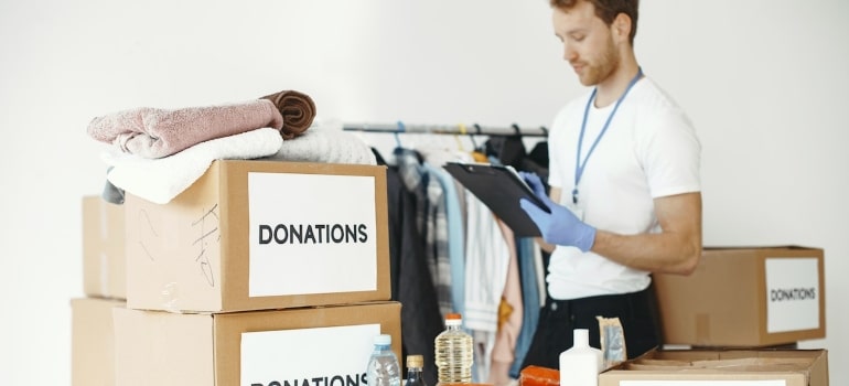 a person surrounded by boxes making an inventory list