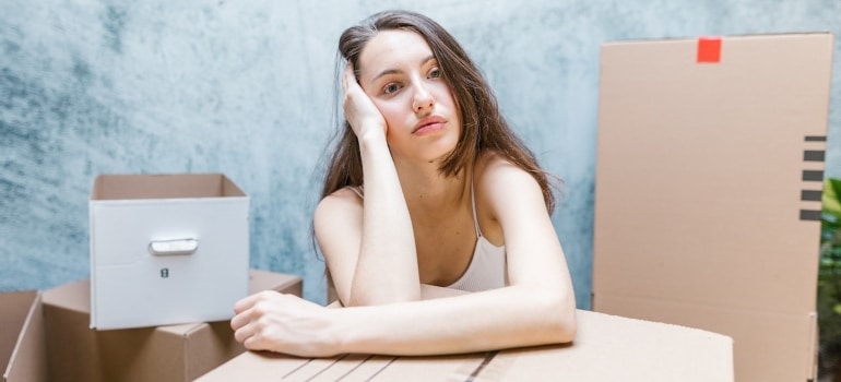 a worried woman thinking about packing tips for moving