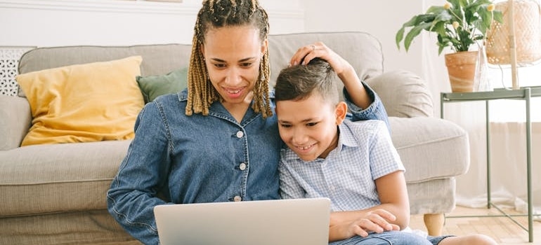 a woman watching something with a child on a laptop