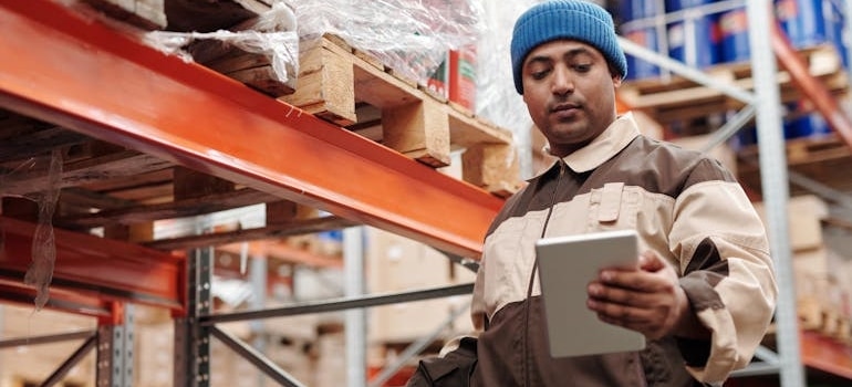 a man in a warehouse using a tablet