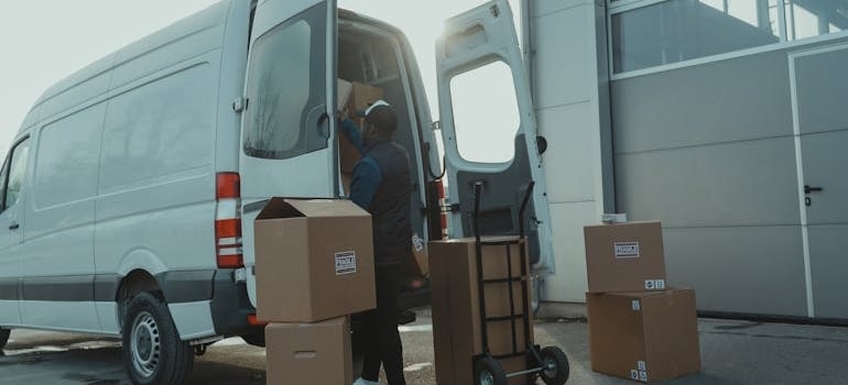 a man loading boxes into a moving van