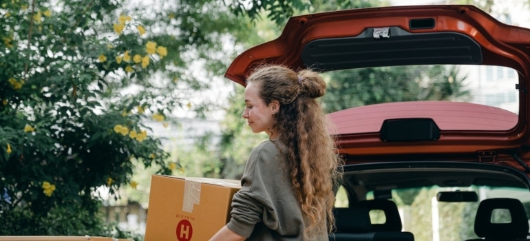 a woman carry a box and moving feels like a stressful time at loading time