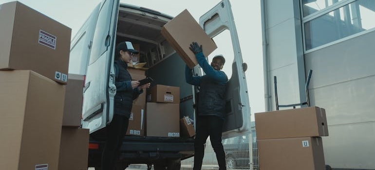 a man placing a heavy box in a moving van